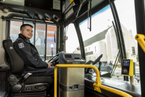 Tap2Ride device on the right side of the bus when rider boards. Driver in seat looking out door. 